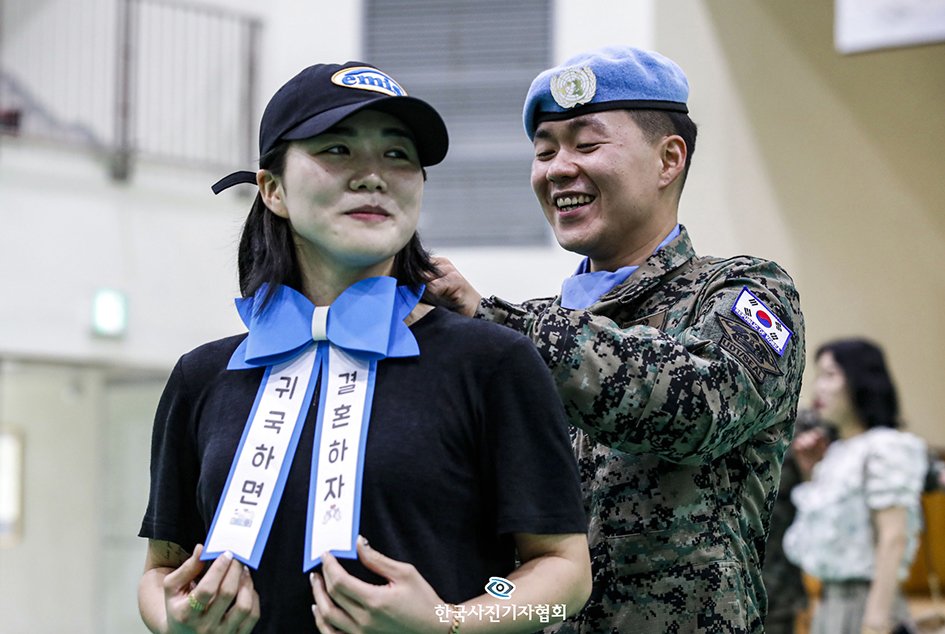 한빛부대&#40;남수단재건지원단&#41; 소속 부대원이 18일 인천 계양구 국제평화지원단에서 열린 한빛부대 17진 환송식에서 약혼자에게 “귀국하면 결혼하자”가 적힌 리본을 달아주며 프러포즈를 하고 있다. 올해로 파병 만 10년을 달성한 한빛부대는 파병기간 동안 남수단의 주요 보급로 및 사회기반시설 복구 등 임무를 수행할 계획이다. 2023.7.18/뉴스1 김도우 기자