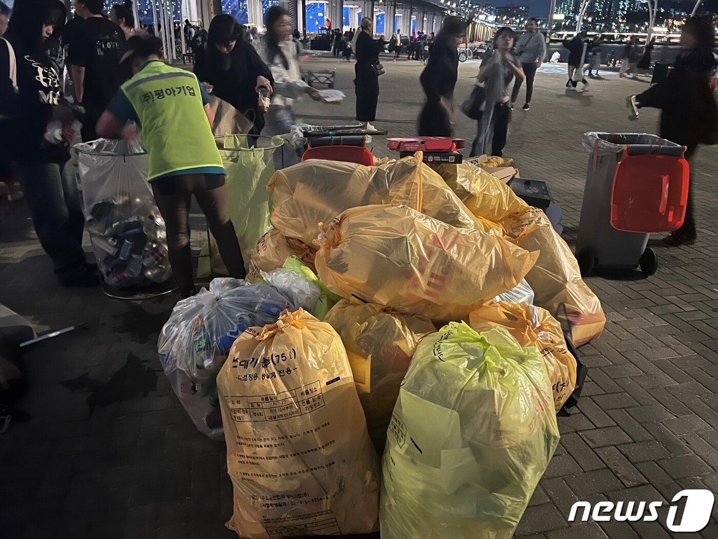 본문 이미지 - 반포 한강공원에 75L짜리 쓰레기봉투가 가득 쌓여 있다. 오후 10시 미화원이 이를 수거해가고 있. /뉴스1