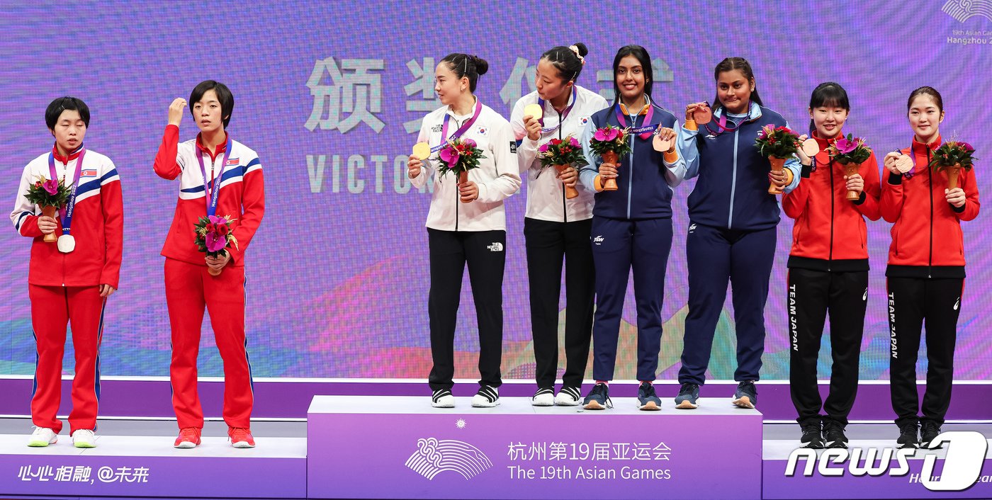 본문 이미지 - 신유빈-전지희가 2일 중국 항저우 궁수 캐널 스포츠파크 체육관에서 열린 2022 항저우 아시안게임 탁구 여자 복식 시상식에서 메달리스트들의 단체 기념 촬영 때 북한 선수들을 부르고 있다. 2023.10.2/뉴스1 ⓒ News1 유승관 기자