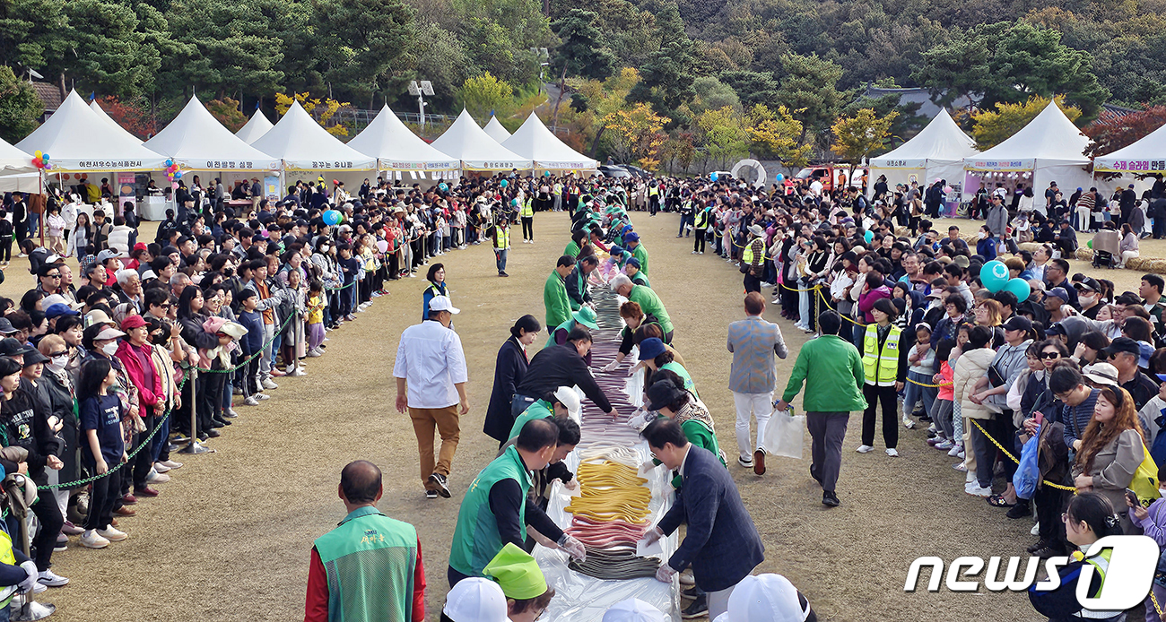 (서울=뉴스1) = 22일 오후 휴일을 맞아 이천농업테마공원에서 열린 '제22회 이천쌀문화축제'에서 방문객들이 600m 무지개 가래떡 행사를 지켜보고 있다. (이천시 제공) 202 …