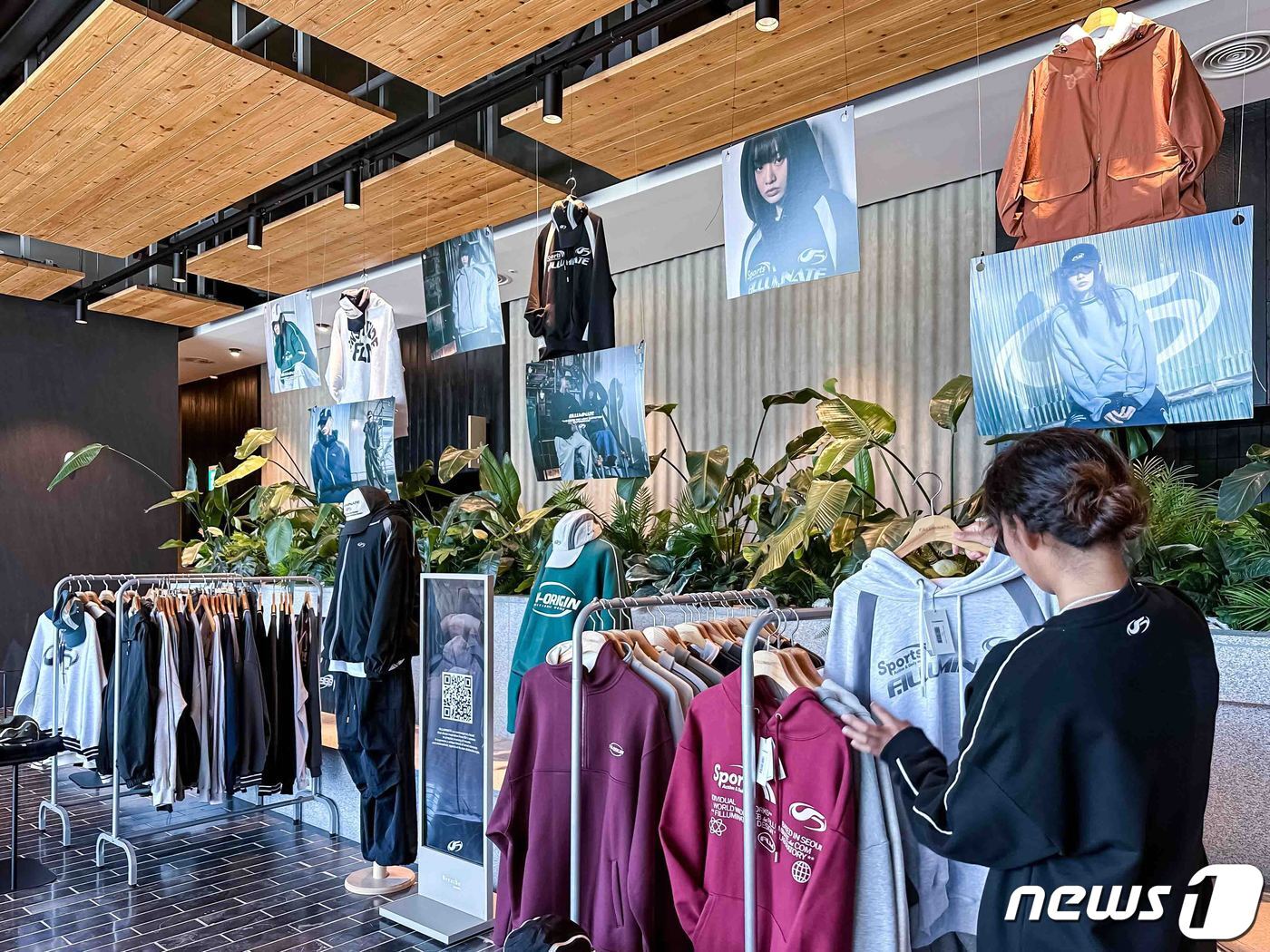 본문 이미지 - 브리드호텔 양양 로비에 전시된 필루미네이트 의류를 고객이 보고 있다(한화호텔앤드리조트 제공).