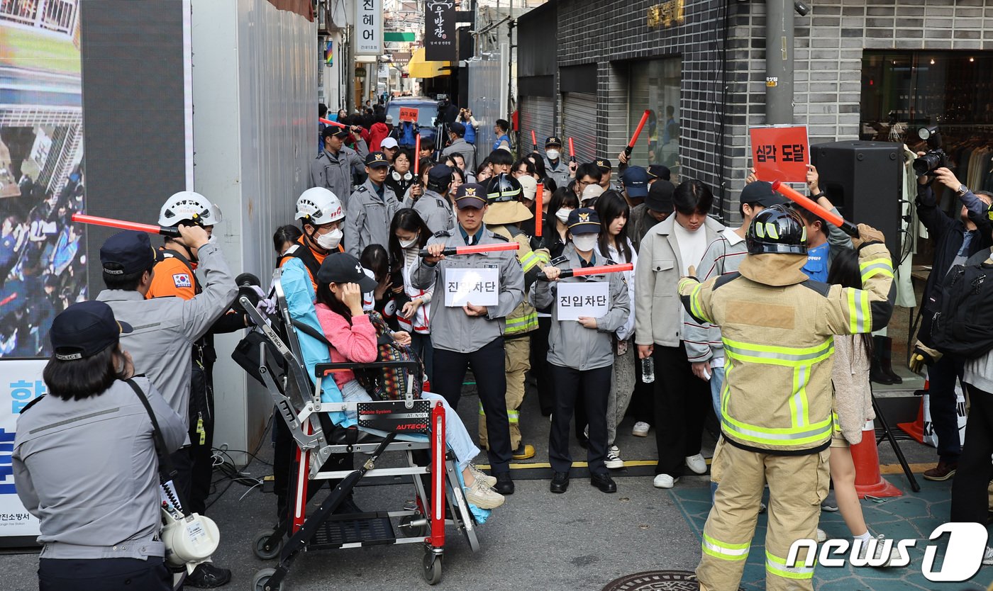 이태원 핼러윈 참사 1주기를 앞둔 25일 서울 광진구 건대맛의거리에서 시민들이 서울시가 새로 도입한 인파감지시스템 활용 유관기관 합동 다중운집 대응 훈련을 하고 있다. 이날 오세훈 서울시장은 이곳을 찾아 주요 인파밀집 지역의 현장 안전관리 계획을 보고받고, 지능형&#40;AI&#41; 폐쇄회로&#40;CC&#41;TV를 활용해 위험 징후를 사전에 알리는 인파감지 시스템을 직접 점검했다. 2023.10.25/뉴스1 ⓒ News1 박지혜 기자