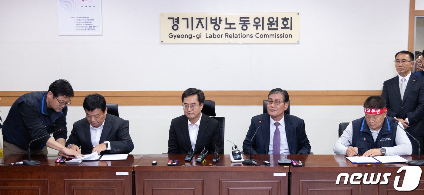 본문 이미지 - 김기성 경기도버스운송사업조합 이사장과 이기천 경기도버스노조협의회 의장이 25일 오후 경기도 수원시 장안구 경기지방노동위원회에서 열린 경기지역자동차노동조합 노동쟁의 조정신청 사건에 대한 조정회의에서 협상이 타결된 후 합의문에 서명하고 있다. 왼쪽부터 김 이사장, 김동연 경기도지사, 우종현 경기지방노동위원회 공익위원, 이 의장. 2023.10.25/뉴스1 ⓒ News1 이재명 기자