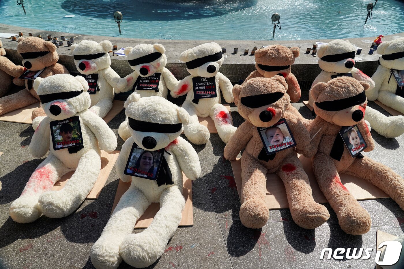 본문 이미지 - 팔레스타인 무장 정파 하마스에 의해 인질로 붙들려간 아이들을 상징하는 곰인형들이 25일(현지시간) 안대를 쓰고 부상을 입은 모습으로 거리에 전시되어 있다. 2023.10.26 ⓒ 로이터=뉴스1 ⓒ News1 정지윤 기자