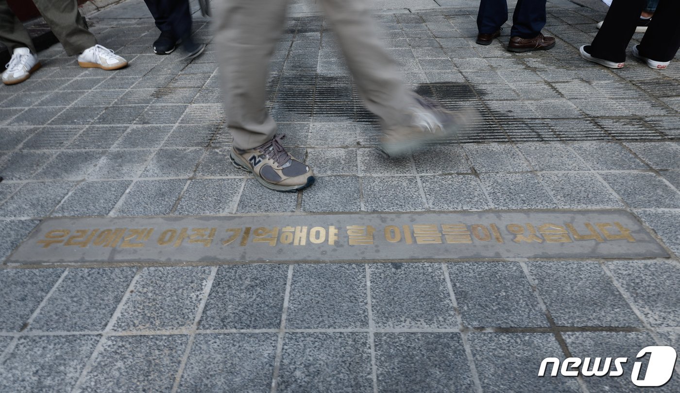 본문 이미지 - 10.29 이태원 참사 1주기를 앞둔 26일 서울 용산구 이태원역 1번 출구 앞 골목 초입에 '우리에겐 아직 기억해야 할 이름들이 있습니다'라는 바닥명판이 새겨져 있다. 2023.10.26/뉴스1 ⓒ News1 안은나 기자