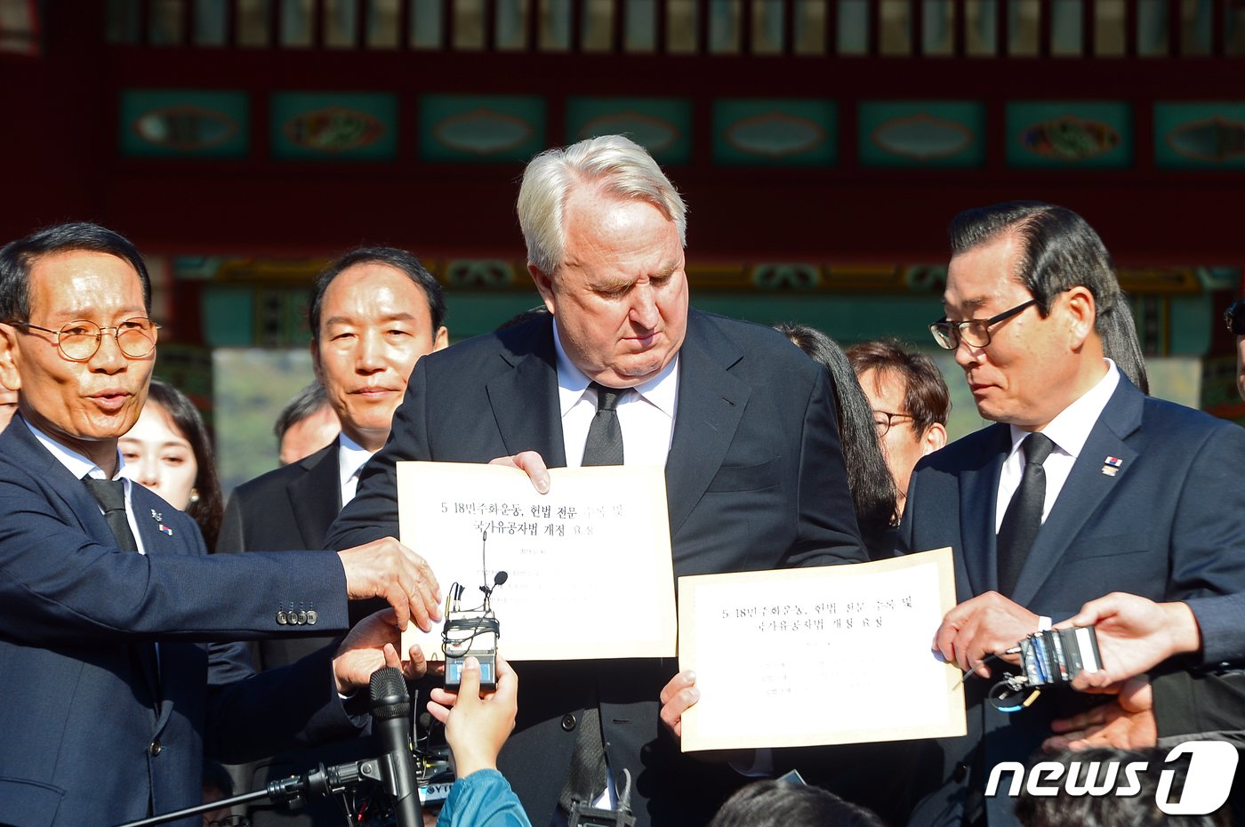 본문 이미지 - 황일봉 공법단체 5·18민주화운동부상자회장&#40;왼쪽&#41;과 정성국 공로자회장&#40;오른쪽&#41;이 30일 오전 광주 북구 운정동 국립5·18민주묘지 민주의문 앞에서 인요한 국민의힘 혁신위원장에게 5·18민주화운동 헌법 전문 수록과 국가유공자법 개정 요청안을 전달하고 있다. 2023.10.30/뉴스1 ⓒ News1 이승현 기자