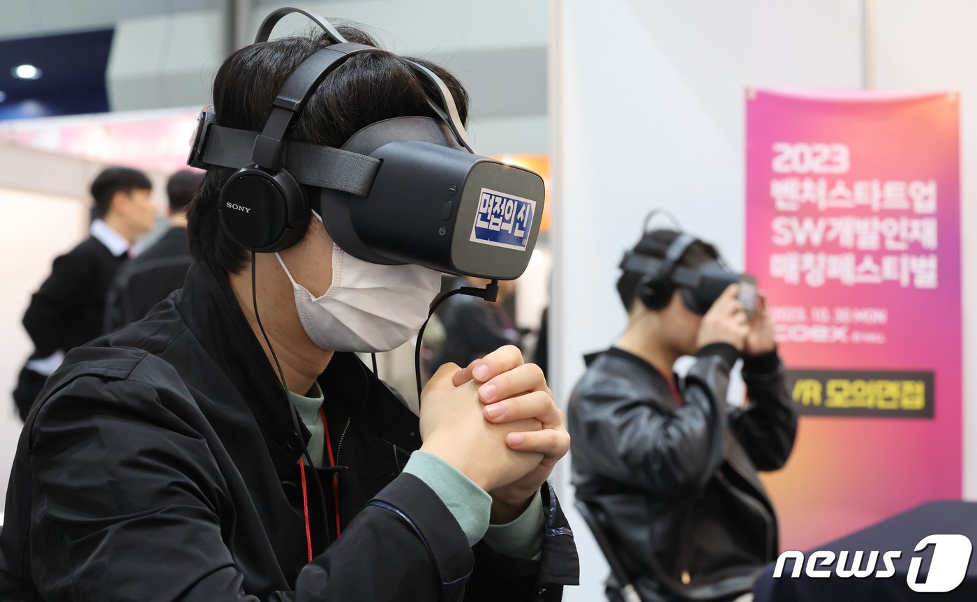 본문 이미지 - 30일 서울 강남구 코엑스에서 열린 '2023 벤처스타트업 SW개발인재 매칭페스티벌'에서 구직자가 VR 모의면접을 보고 있다. 중소벤처기업부가 주최한 이번 행사는 소프트웨어(SW) 분야 글로벌 인재유치 경쟁에 따른 인력난 해소를 위해 마련됐다. 2023.10.30/뉴스1 ⓒ News1 김도우 기자