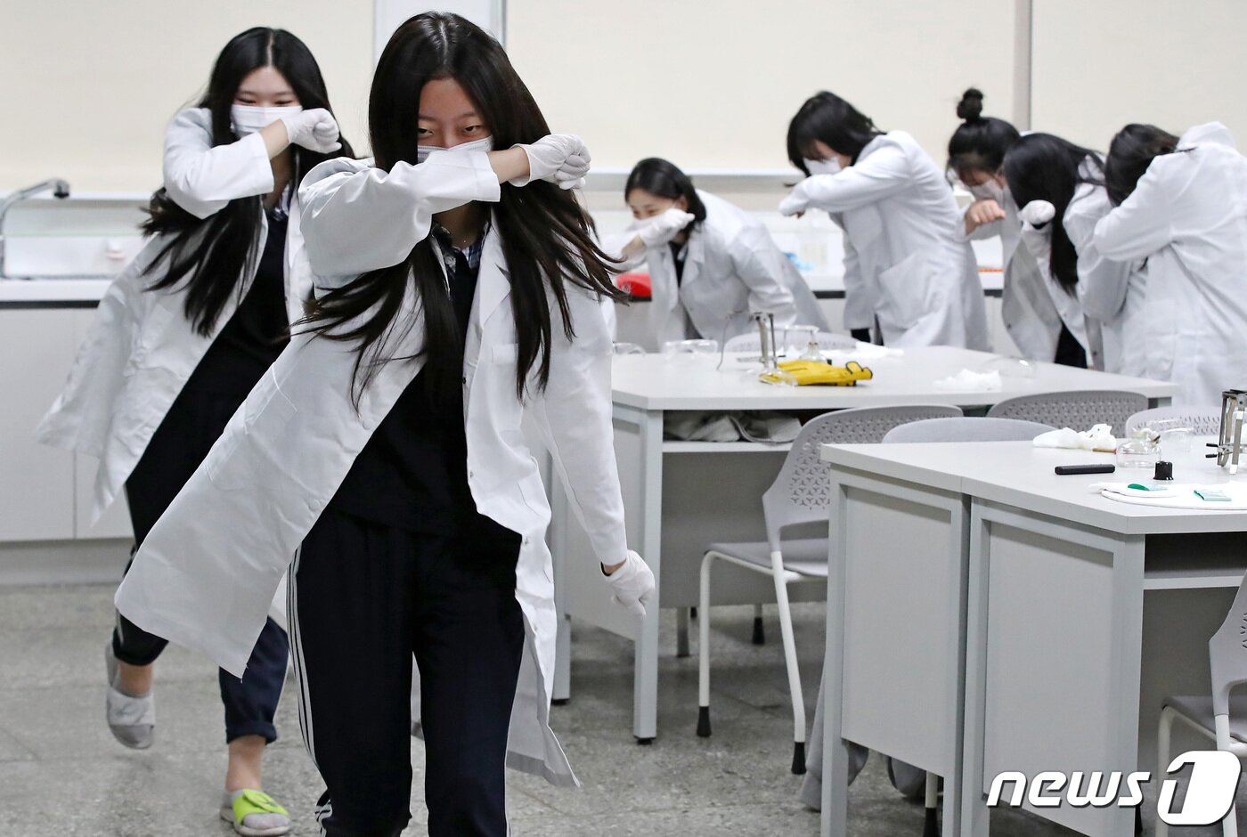 본문 이미지 - 31일 오후 대구 달서구 원화여고 화학실험실에서 열린 '2023년 재난대응 안전한국훈련'에 참여한 학생들이 알코올램프를 이용한 실험 도중 화재 발생 상황을 가정해 코와 입을 막으며 건물 외부로 대피하고 있다. 2023.10.31/뉴스1 ⓒ News1 공정식 기자