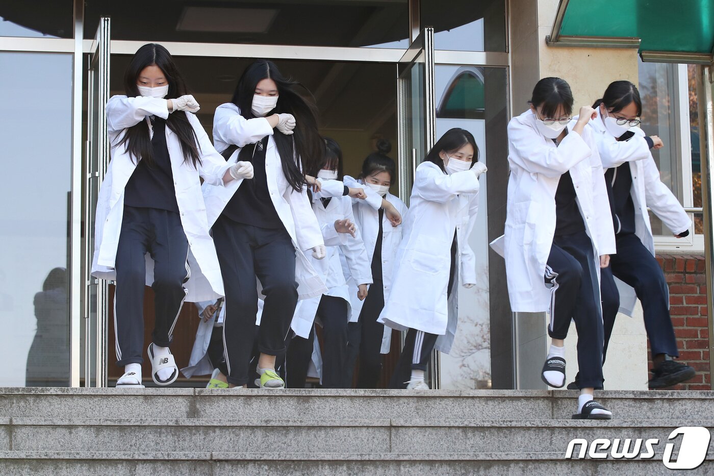 본문 이미지 - 31일 오후 대구 달서구 원화여고 화학실험실에서 열린 '2023년 재난대응 안전한국훈련'에 참여한 학생들이 알코올램프를 이용한 실험 도중 화재 발생 상황을 가정해 코와 입을 막으며 건물 외부로 대피하고 있다. 2023.10.31/뉴스1 ⓒ News1 공정식 기자