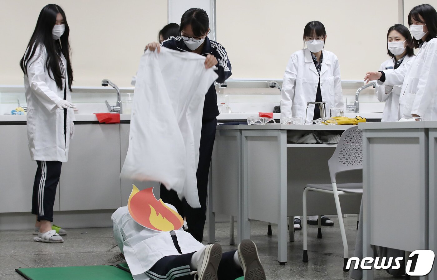 본문 이미지 - 31일 오후 대구 달서구 원화여고 화학실험실에서 열린 '2023년 재난대응 안전한국훈련'에 참여한 학생들이 알코올램프를 이용한 실험 도중 화재 발생 상황을 가정해 가운을 벗어 학생 옷에 붙은 불을 끄고 있다. 2023.10.31/뉴스1 ⓒ News1 공정식 기자