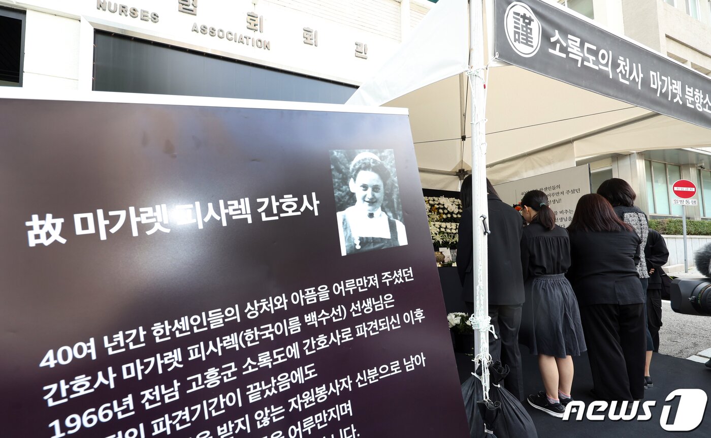 본문 이미지 - 대한간호협회 관계자 및 간호사들이 4일 오전 서울 중구 동호로 대한간호협회회관 앞에 마련된 고 마가렛 피사렉 국민 분향소에서 열린 추모식에서 헌화하고 있다. 2023.10.4/뉴스1 ⓒ News1 박정호 기자