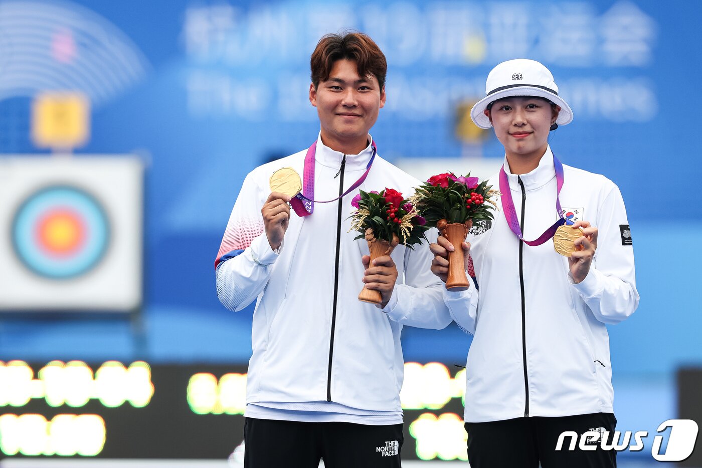 본문 이미지 - 이우석과 임시현이 4일 중국 항저우 푸양 인후 스포츠센터 양궁장에서 열린 2022 항저우 아시안게임 양궁 리커브 혼성전 시상식을 마친 후 취재진을 향해 금메달을 들어보이고 있다. 이우석과 임시현은 이날 결승에서 일본의 노다 사츠키-후루카와 다카하루에게 6-0 완승을 거두고 금메달을 차지했다. 2023.10.4/뉴스1 ⓒ News1 유승관 기자