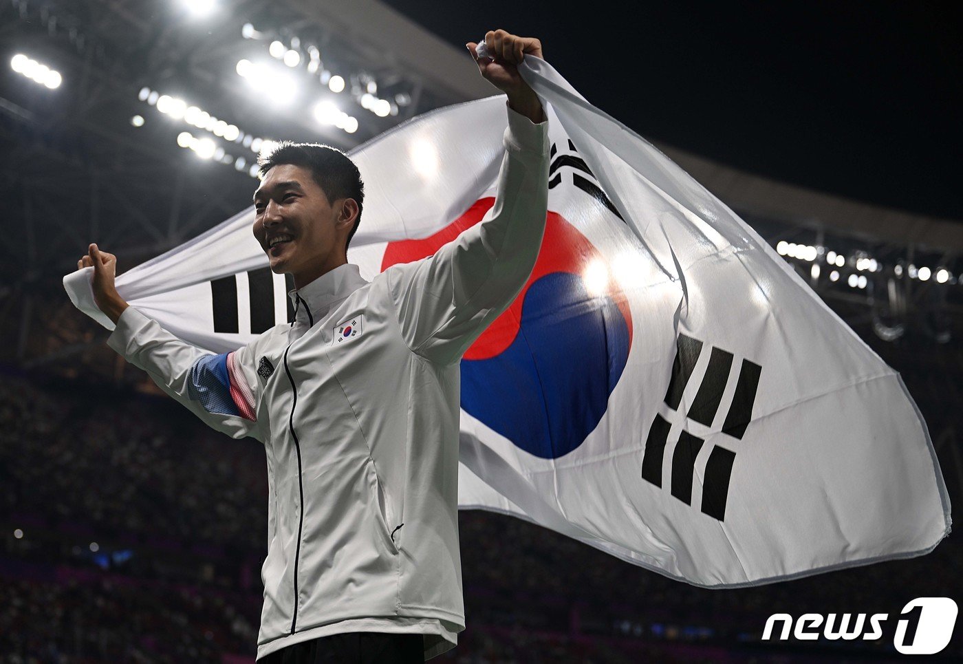 본문 이미지 - 우상혁이 4일 오후 중국 항저우 올림픽 스포츠센터 스타디움에서 열린 2022 항저우 아시안게임 남자 높이뛰기 결선에서 은메달을 확정지은 뒤 태극기를 펼쳐들고 있다. (공동취재) 2023.10.4/뉴스1 ⓒ News1 신웅수 기자