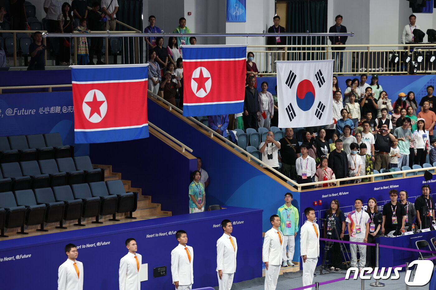 본문 이미지 - 5일 중국 항저우 샤오산 스포츠센터에서 열린 2022 항저우 아시안게임 여자 역도 76kg급 시상식에서 대한민국 김수현과 북한 성국향, 정춘희가 동메달과 금·은메달을 차지해 태극기와 인공기가 함께 게양되고 있다. 2023.10.5/뉴스1 ⓒ News1 민경석 기자