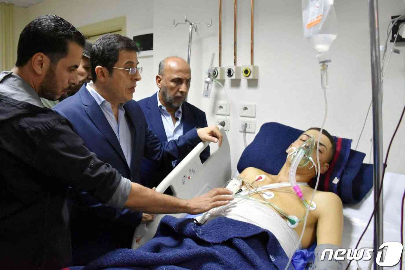 하산 알-가바시 보건부 장관이 5일(현지시간) 발생한 폭탄 테러 부상자를 병문안하고 있다. 가운데가 장관. © AFP=뉴스1 © News1 박형기 기자