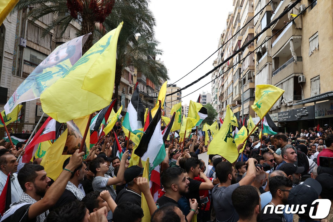 본문 이미지 - 8일(현지시간) 레바논 베이루트 남부 교외에서 헤즈볼라 지지자들이 깃발을 들고 팔레스타인과 연대를 표현하고 있다. 2023.10.08/ ⓒ 로이터=뉴스1 ⓒ News1 권진영 기자