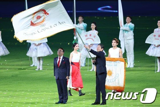 8일 오후 중국 항저우 올림픽 스포츠센터 스타디움에서 열린 2022 항저우 아시안게임 폐회식에서 2026 아시안게임 개최지인 일본 아이치현의 오무라 히데아키 지사가 대회기를 이양 받은 뒤 힘차게 흔들고 있다. 2023.10.8/뉴스1 © News1 신웅수 기자