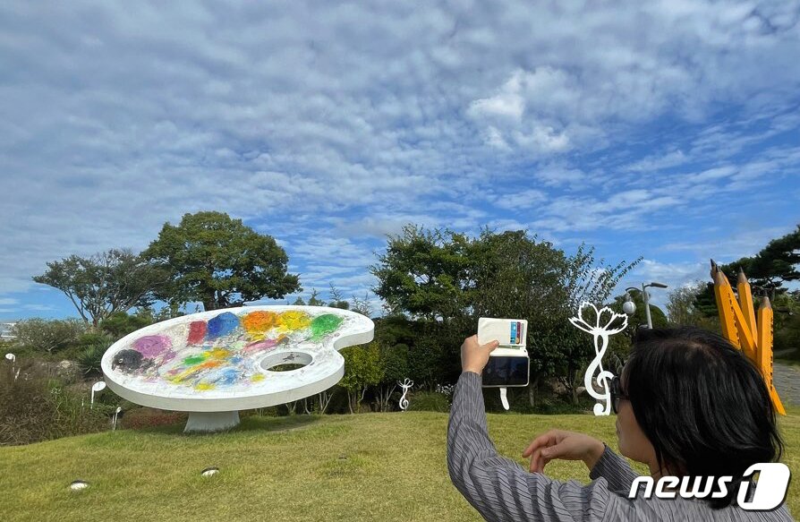 본문 이미지 - 9일 오전 순천만국제정원박람회장을 찾은 관람객들이 파란 가을하늘을 스마트폰에 담고 있다. 2023.10.9 / ⓒ News1 김태성 기자
