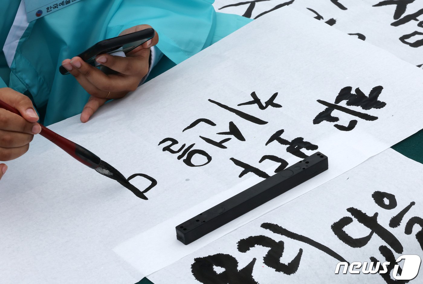 본문 이미지 - 577돌 한글날인 9일 오전 서울 광화문광장에서 열린 휘호경진대회에서 한 외국인 참가자가 정성스럽게 글씨를 써내려가고 있다. 2023.10.9/뉴스1 ⓒ News1 이동해 기자