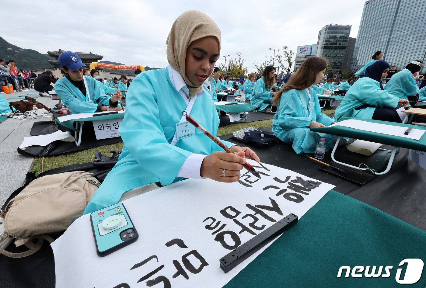 본문 이미지 - 577돌 한글날인 9일 오전 서울 광화문광장에서 열린 휘호경진대회에서 참가자들이 정성스럽게 글씨를 써내려가고 있다. 2023.10.9/뉴스1 ⓒ News1 이동해 기자
