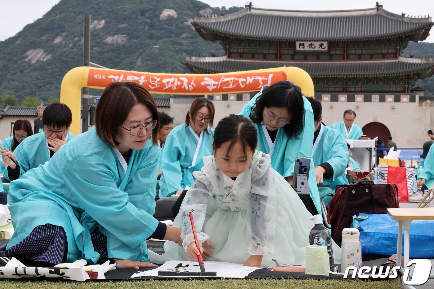본문 이미지 - 577돌 한글날인 9일 오전 서울 광화문광장에서 열린 휘호경진대회에서 참가자들이 정성스럽게 글씨를 써내려가고 있다. 2023.10.9/뉴스1 ⓒ News1 이동해 기자