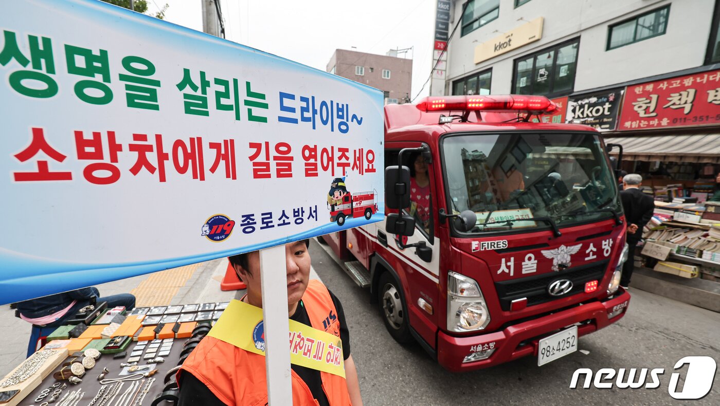 본문 이미지 - 서울종로소방서 대원들과 종로 의용소방대원들이 1일 오후 서울 종로구 동묘 벼룩시장에서 재난대응 안전한국훈련의 일환으로 소방차 길터주기 훈련을 하고 있다. 2023.11.1/뉴스1 ⓒ News1 김도우 기자