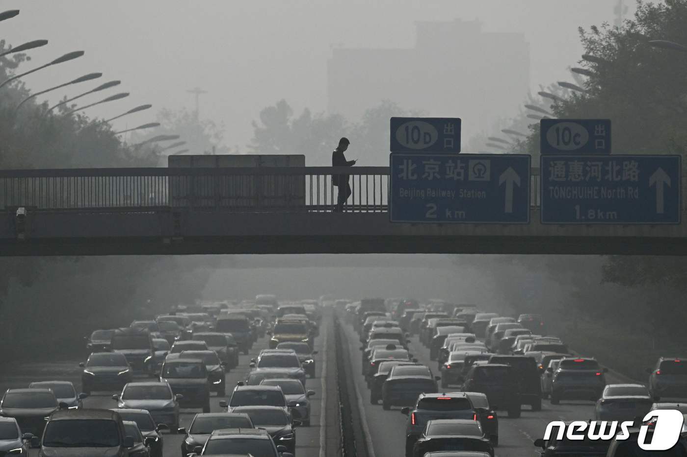 본문 이미지 - 엄청난 스모그에도 태연하게 육교위를 지나가는 한 행인. 2023.11.01 ⓒ AFP=뉴스1 ⓒ News1 정지윤 기자