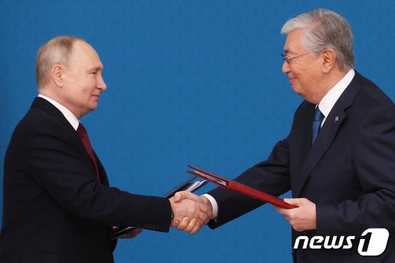 [사진] 협정서 서명하고 악수하는 푸틴과 카자흐 대통령