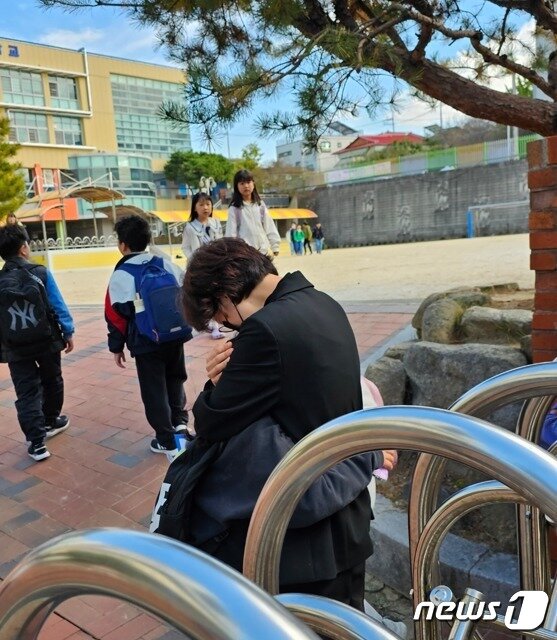 본문 이미지 - 24일 광주 북구 한 초등학교 앞에서 열린 A교사 교권회복 촉구 집회에서 하교 하던 학생들이 A교사를 찾아 인사하자 A교사가 껴안고 있다. A교사는 학생 간 싸움을 말리는 과정에서 책상을 밀쳤다가 아동학대 혐의로 학부모에 고소당해 검찰에서 무혐의 처분을 받았다. 학교 측은 이날 A교사에 대한 교권보호위원회를 열었다.(초등교사노조 제공)2023.10.24./뉴스1