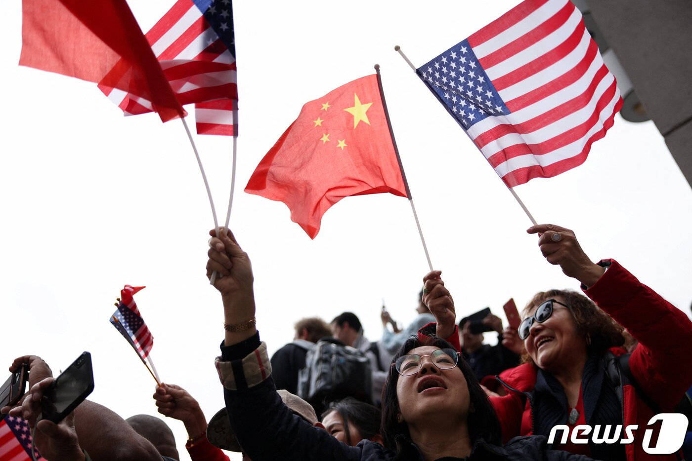 본문 이미지 - 시진핑 중국 국가주석이 14일(현지시간) 미중 정상회담과 아시아태평양경제협력체(APEC) 정상회의에 참석하기 위해 캘리포니아주 샌프란시스코 국제 공항에 도착한 가운데, 지지자들이 오성홍기와 성조기를 들며 그의 방문을 환영하고 있다. ⓒ 로이터=뉴스1 ⓒ News1 정윤영 기자