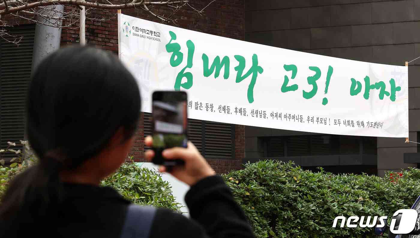 2024학년도 대학수학능력시험 예비소집일인 15일 서울 중구 이화여고에서 한 수험생이 시험장 앞에 붙은 응원 현수막을 스마트폰에 담고 있다. 2023.11.15/뉴스1 © News1 박지혜 기자