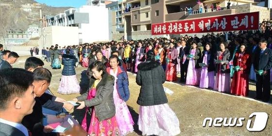새 살림집 입사증 받아 든 북한 주민들…