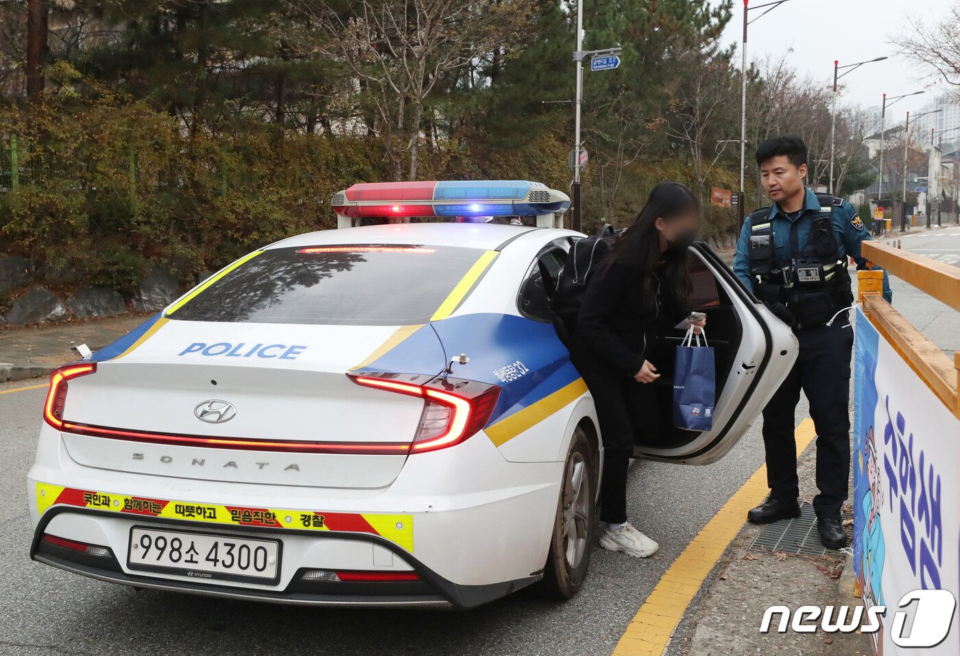 본문 이미지 - 수능일인 16일 오전 경기 화성시 나루고에서 한 수험생이 경찰차를 타고 시험장에 도착하고 있다. 2023.11.16/뉴스1 ⓒ News1 김영운 기자