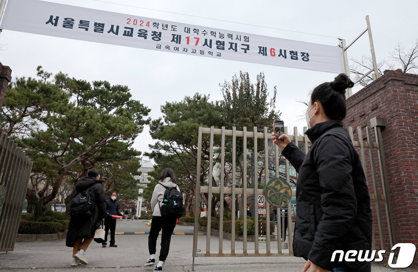 본문 이미지 - 2024학년도 대학수학능력시험일인 16일 오전 서울 양천구 금옥여자고등학교에서 한 부모님이 시험장에 들어가는 수험생을 카메라로 찍고 있다. 2023.11.16/뉴스1 ⓒ News1 장수영 기자