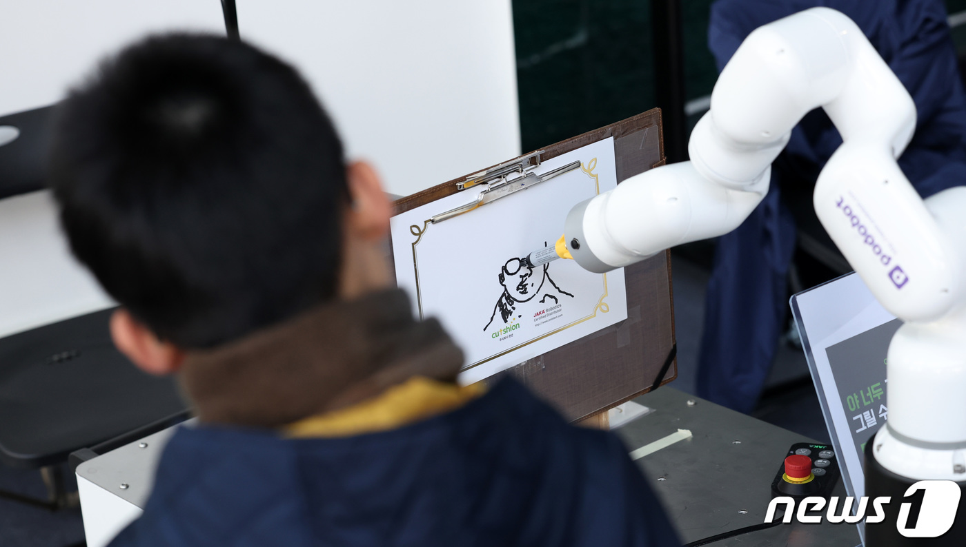 (서울=뉴스1) 김성진 기자 = 19일 서울 강남구 코엑스에서 열린 제1회 강남 로봇 플러스 페스티벌에서 한 어린이가 드로잉 로봇의 그림 실력을 구경하고 있다. 2023.11.19 …