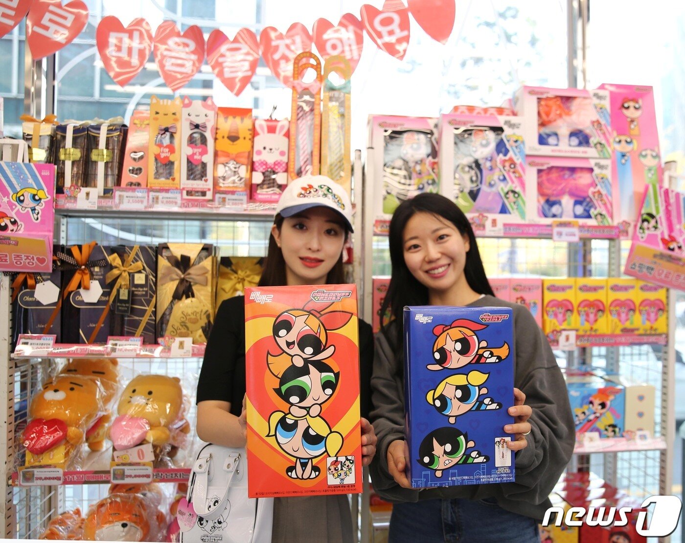 본문 이미지 - GS25 매장에서 모델들이 파워퍼프걸 협업 상품을 들어 보이고 있다.(GS25 제공)