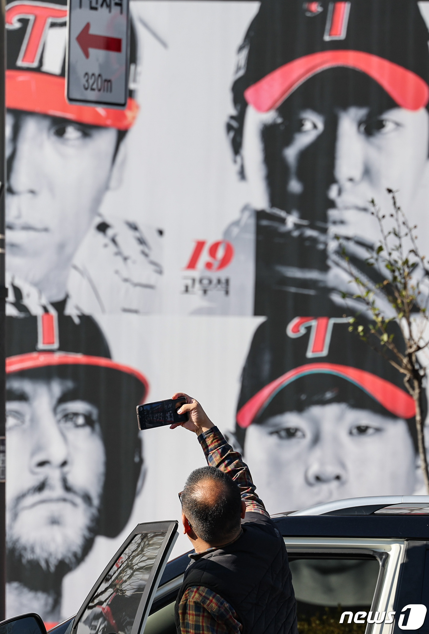 (서울=뉴스1) 김도우 기자 = 20일 서울 종로구 한 건물 외벽에 LG 트윈스의 프로야구 한국시리즈 우승을 기념해 한 팬카페가 제작한 대형 포스터 앞에서 한 운전자가 차에서 내려 …