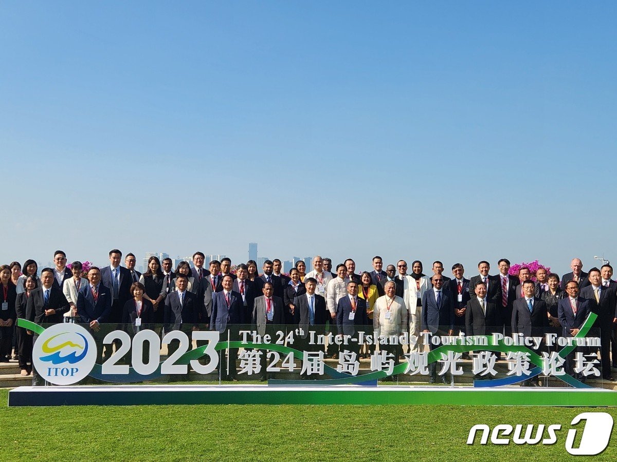 본문 이미지 - 지난 19일부터 21일까지 중국 하이난성에서 열리고 있는 제24회 섬관광정책포럼에 참석한 각 섬 지역 대표단이 기념촬영을 하고 있다 