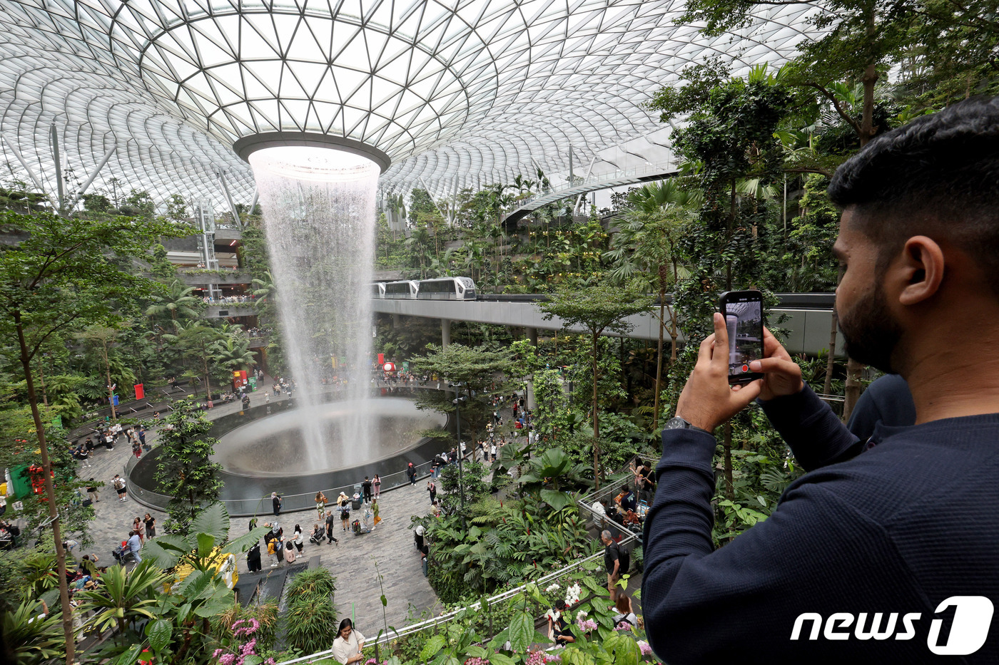 (싱가포르=뉴스1) 장수영 기자 = 23일 오전(현지시간) 싱가포르 창이국제공항 쥬얼창이를 찾은 관광객들이 인공폭포를 관람하고 있다.쥬얼창이는 기존 창이공항 시설 확장 및 허브 공 …