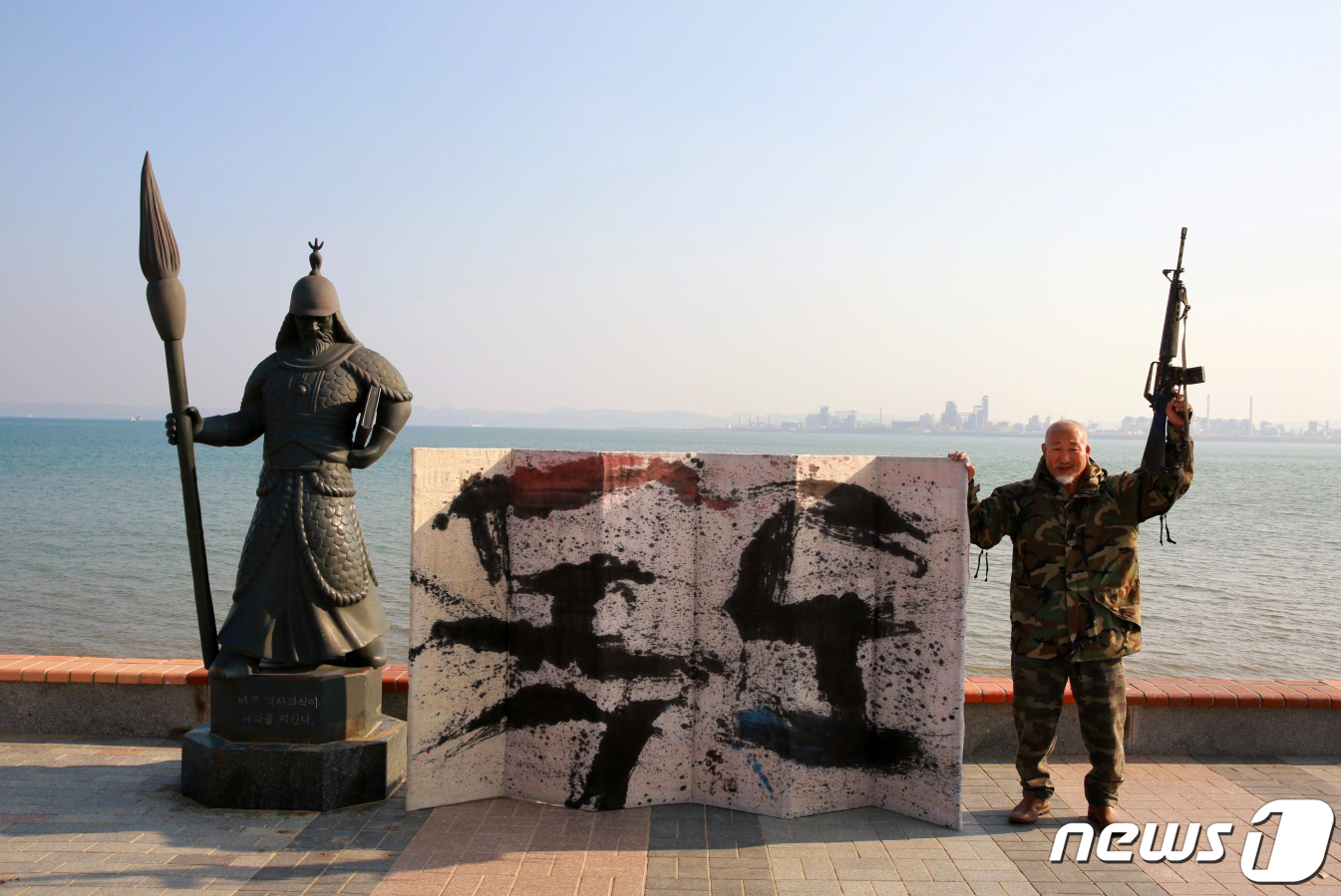 (포항=뉴스1) 최창호 기자 = 서예가 김동욱 씨가 23일 경북 포항시 북구 영일대해수욕장 붓을 든 이순신 동상 앞에서 '독도대첩'기념하는 퍼포먼스를 하고 있다.독도대첩은 1954 …