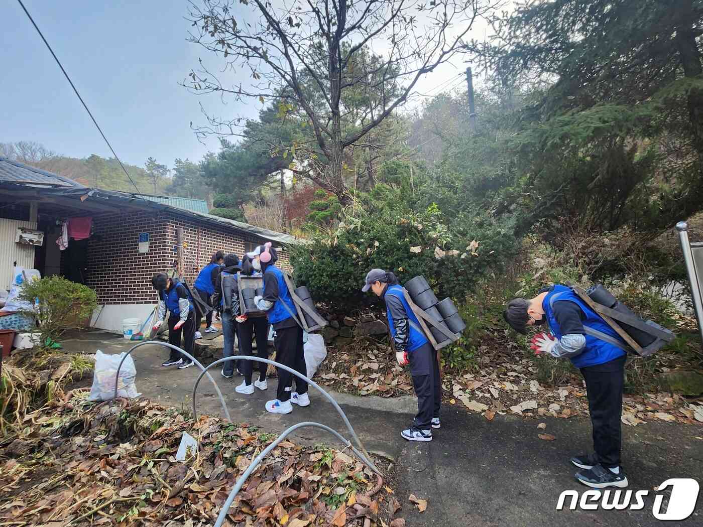 지난 23일 봉사자들이 연탄을 짊어진 채 대기하고 있다.2023.11.23/뉴스1 ©News1 장성희 기자