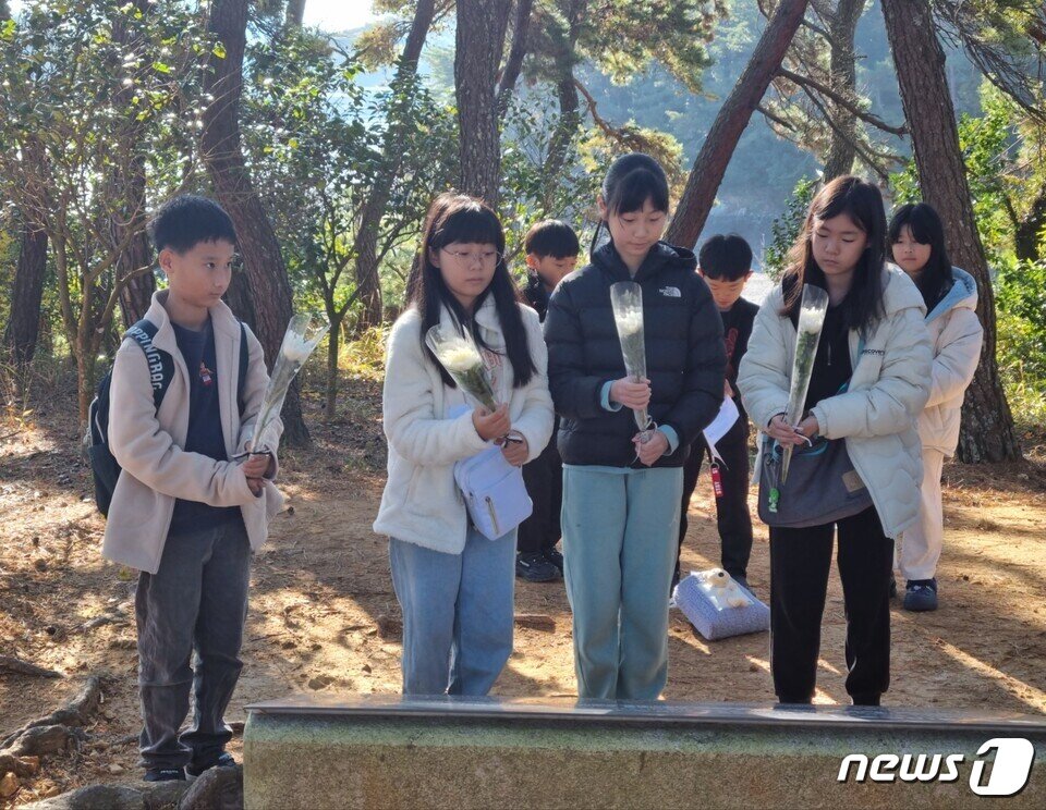 본문 이미지 - 신지동초등학교(교장 조윤자)- 21일 우리 고장 역사 탐방 프로그램 '충무공 이순신의 바다를 가슴에 품다'에 참여한 학생들이 충무공의 가묘가 있던 월송대를 찾아 헌화하고 있다.(전남교육청 제공)/뉴스1 