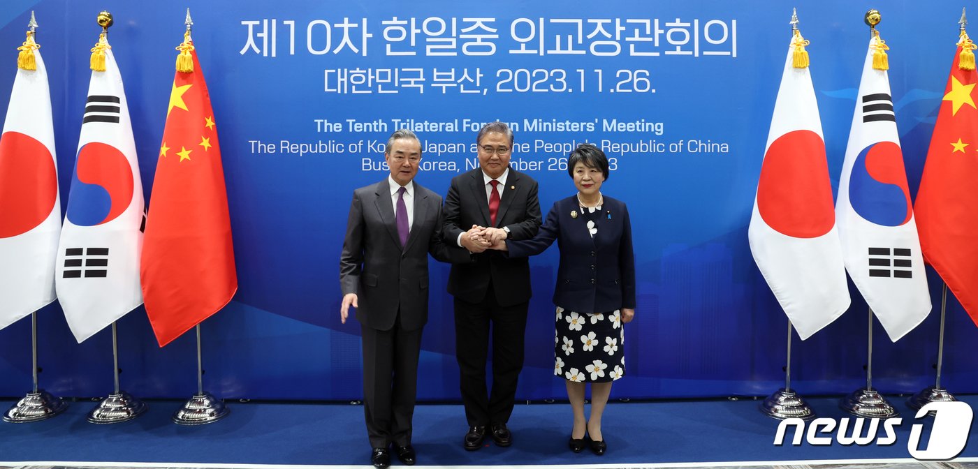 본문 이미지 - 박진(가운데) 외교부 장관, 가미카와 요코(오른쪽) 일본 외무상, 왕이 중국 외교부장이 26일 오후 부산 해운대구 시그니엘 부산에서 열린 한일중 외교장관 회의에서 손을 맞잡고 기념촬영을 하고 있다. 2023.11.26/뉴스1 ⓒ News1 김명섭 기자