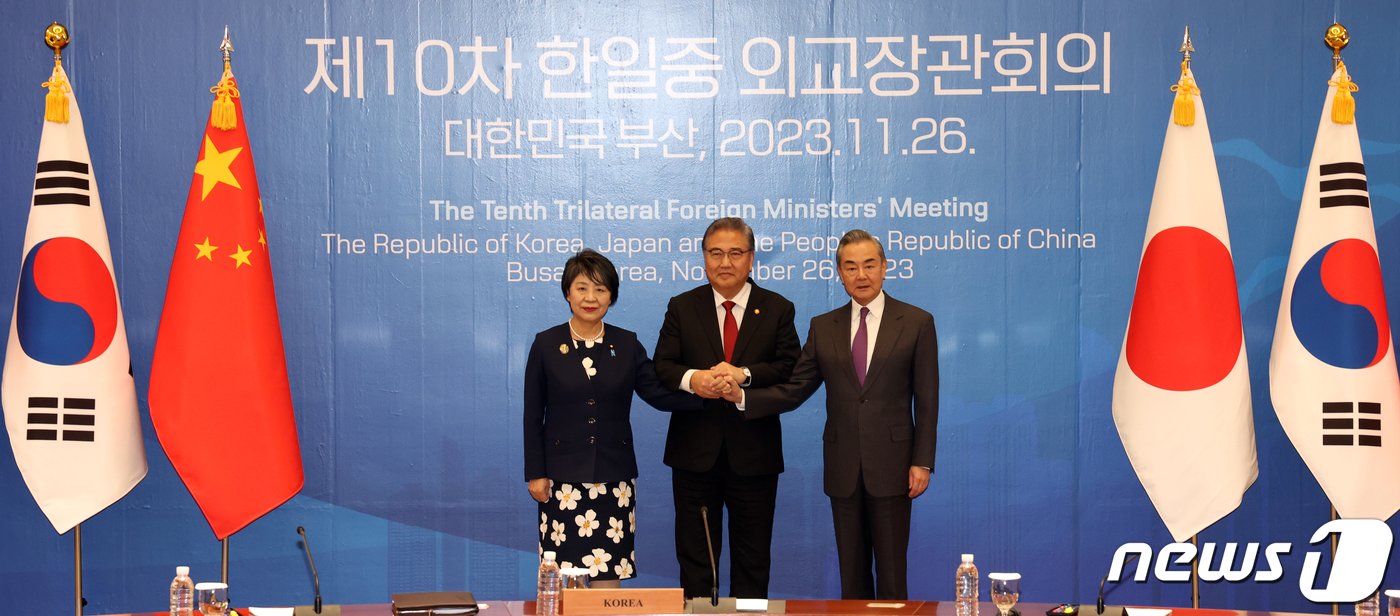 본문 이미지 - 지난해 11월 박진&#40;가운데&#41; 당시 외교부 장관, 가미카와 요코&#40;왼쪽&#41; 일본 외무상, 왕이 중국 외교부장이 부산 해운대구 누리마루 APEC하우스에서 열린 한일중 외교장관 회의에서 손을 맞잡고 기념촬영을 하고 있다. 2023.11.26/뉴스1 ⓒ News1 김명섭 기자