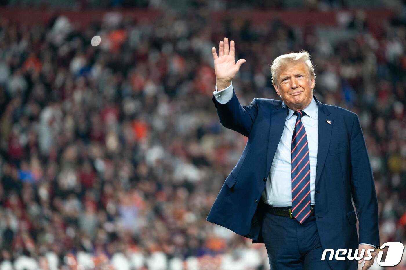 본문 이미지 - 도널드 트럼프 전 미국 대통령이 25일(현지시간) 사우스캐롤라이나주 컬럼비아에서 열린 대학 미식축구 경기 하프타임 동안 그라운드서 관중에게 손을 흔들고 있다. 2023.11.27 ⓒ AFP=뉴스1 ⓒ News1 우동명 기자