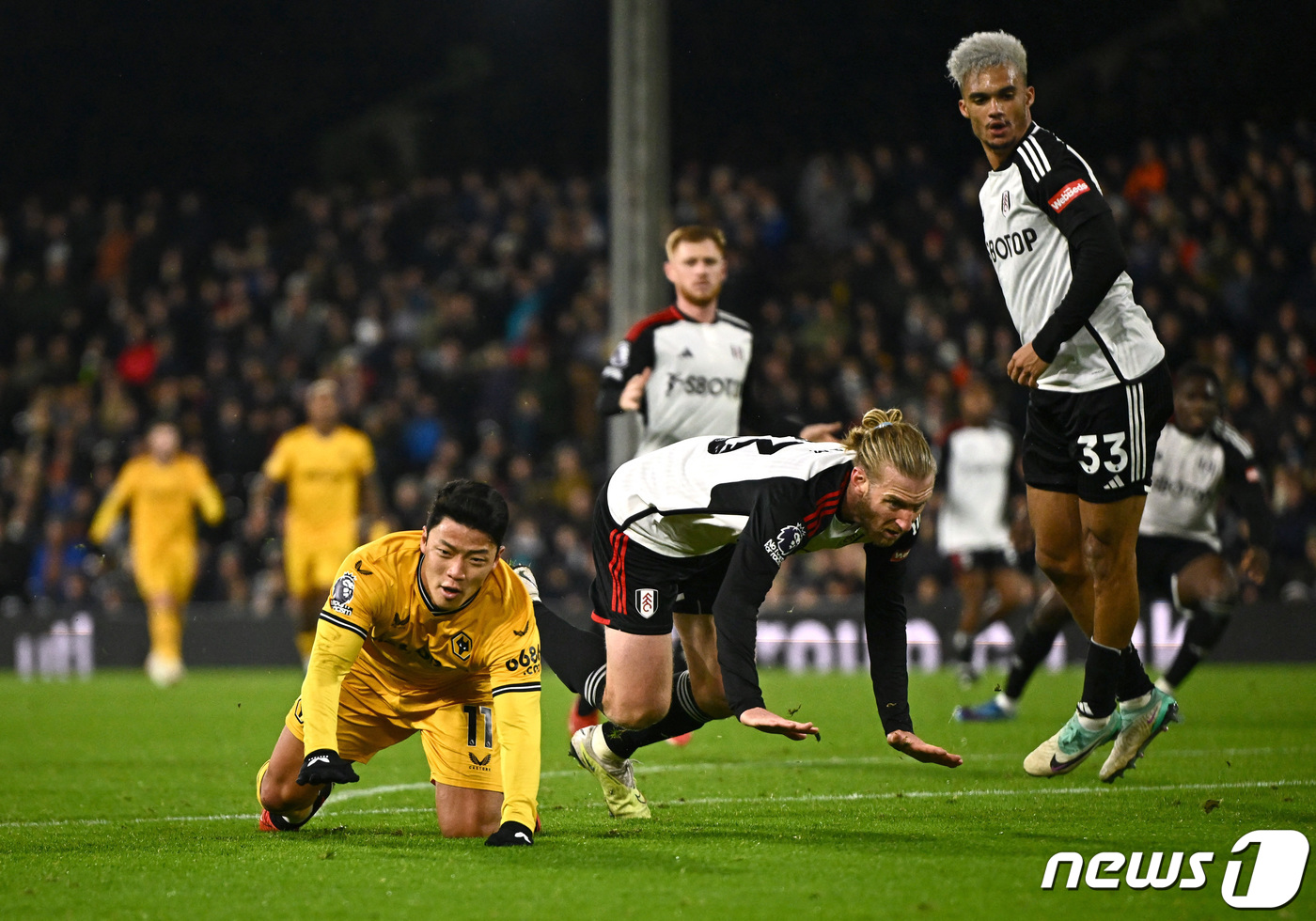 (런던 로이터=뉴스1) 우동명 기자 = 울버햄프턴의 황희찬이 27일(현지시간) 영국 런던의 크레이븐 코티지에서 열린 EPL 풀럼과 경기서 상대 선수 팀 림과 안토니 로빈슨에게 파울 …