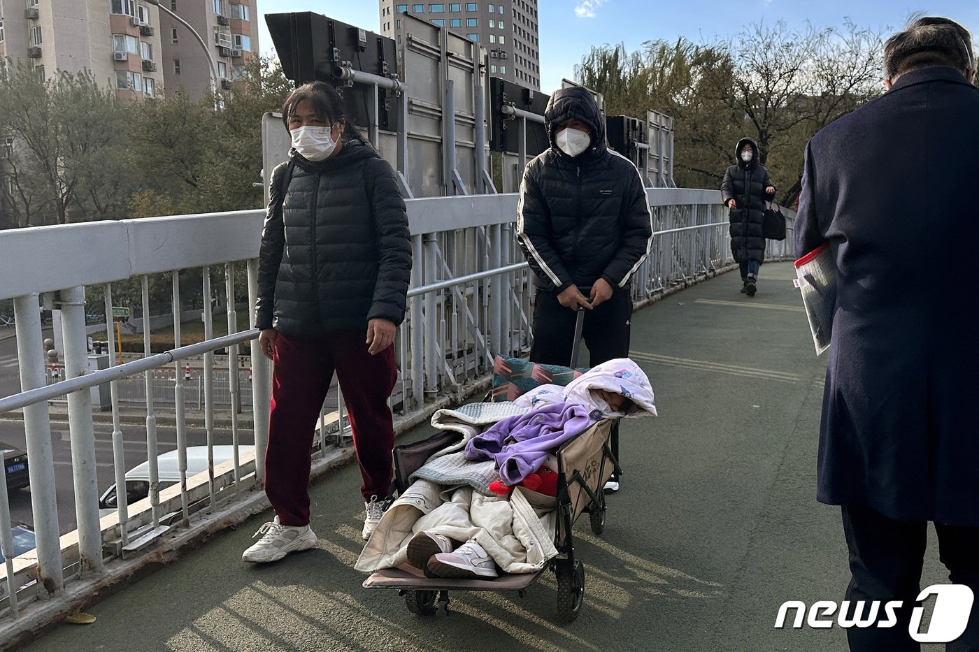 27일 중국의 한 아버지가 아이를 카트에 싣고 베이징 아동병원으로 향하고 있다. ⓒ 로이터=뉴스1 ⓒ News1 박형기 기자