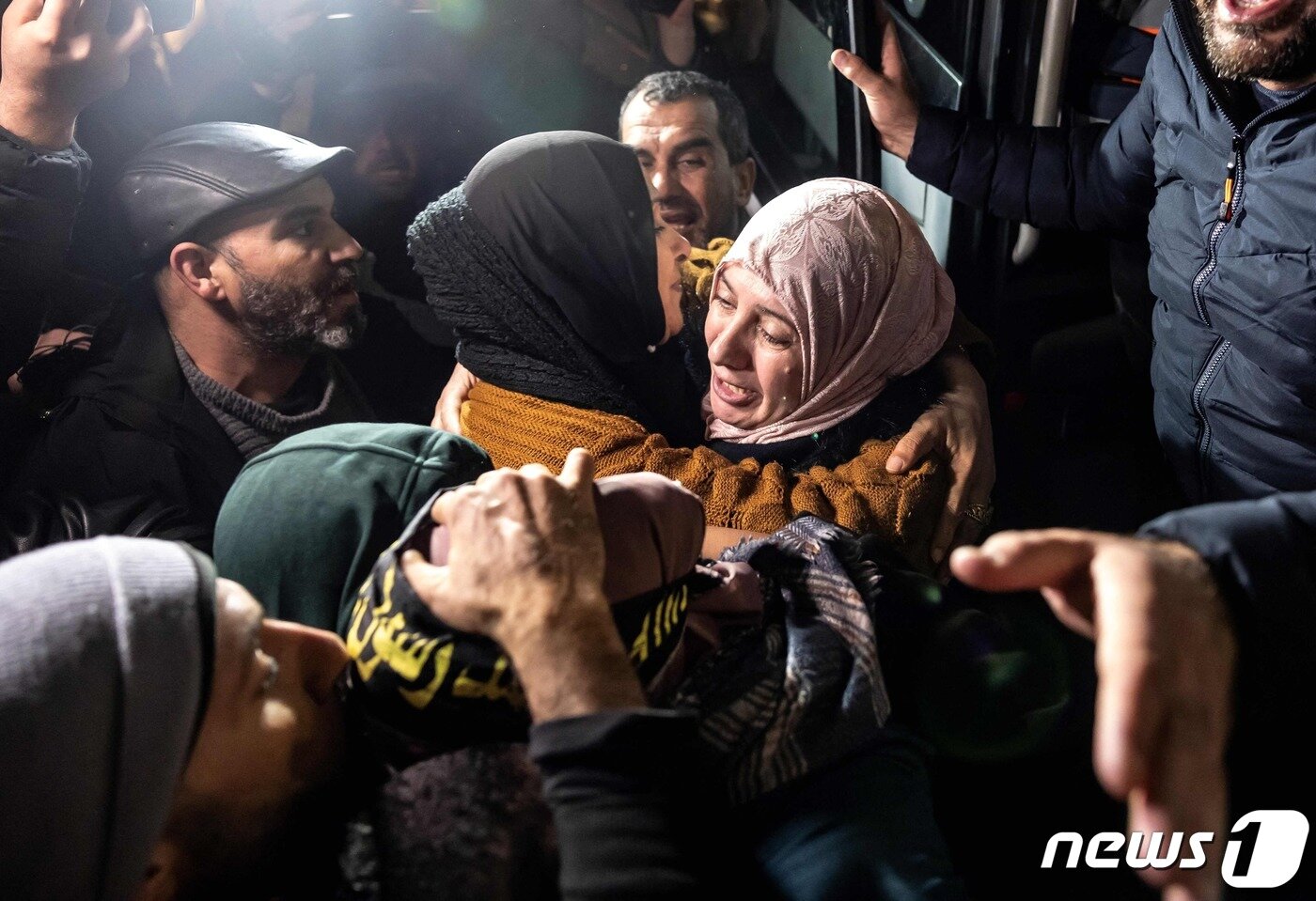 본문 이미지 - 이스라엘 감옥에서 석방된 한 팔레스타인 여성이 28일(현지시간) 요르단강 서안지구에서 그의 친척과 지지자들에 둘러싸여 있다. 2023.11.28 ⓒ AFP=뉴스1 ⓒ News1 정지윤 기자