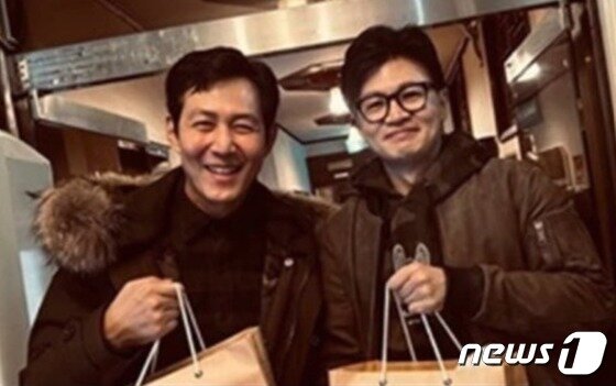 본문 이미지 - 한동훈 법무부 장관과 영화배우 이정재가 지난 26일 밤 서울 서초구 B갈빗집에서 저녁을 함께 한 뒤 포장음식을 손에 든 채 사진촬영요청에 응하고 있다. (SNS 갈무리) ⓒ 뉴스1