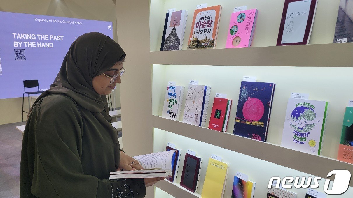 본문 이미지 - 2일 아랍에미리트(UAE) 샤르자의 엑스포 센터 샤르자에서 진행 중인 '2023 샤르자국제도서전'의 한국관을 찾은 관람객 암나 알시시가 한국 책을 살펴보고 있다. ⓒ 뉴스1 김정한 기자